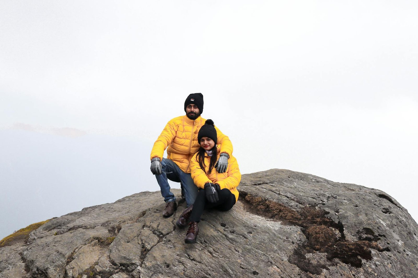 Couple portant des vestes de randonnée sur un sommet en montagne