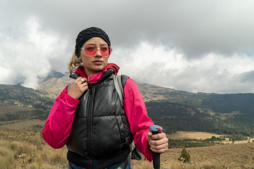 Randonneuse en tenue colorée sur un sentier de montagne nuageux