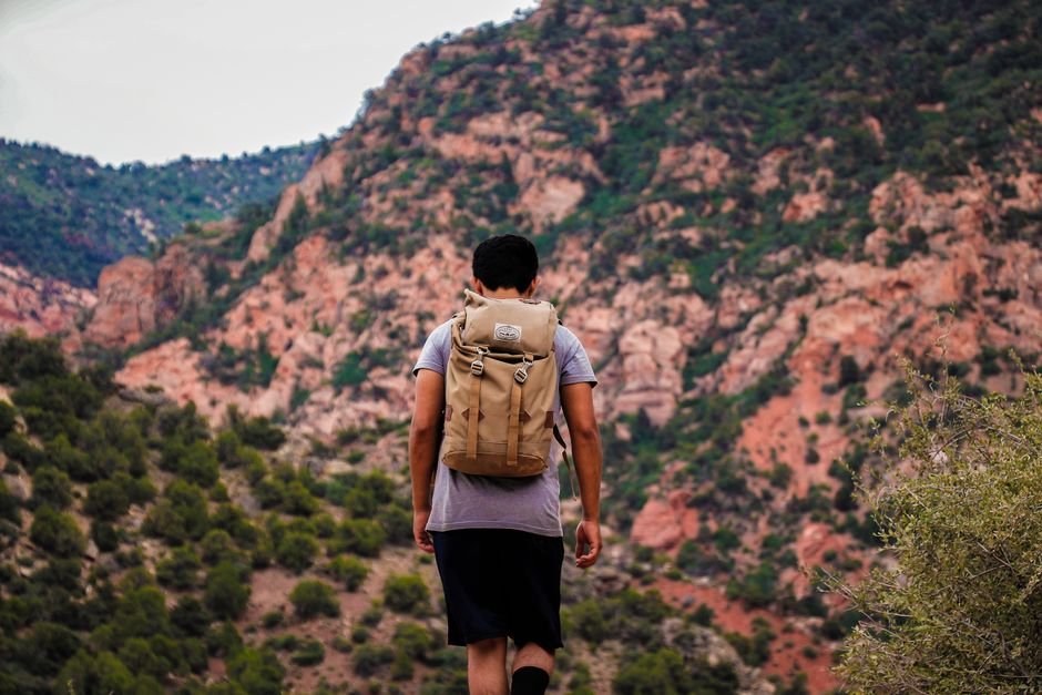 Débutant en randonnée sur un sentier de montagne avec sac à dos