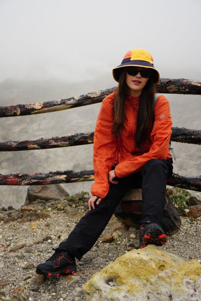 Randonneuse en veste orange sur un sentier de montagne